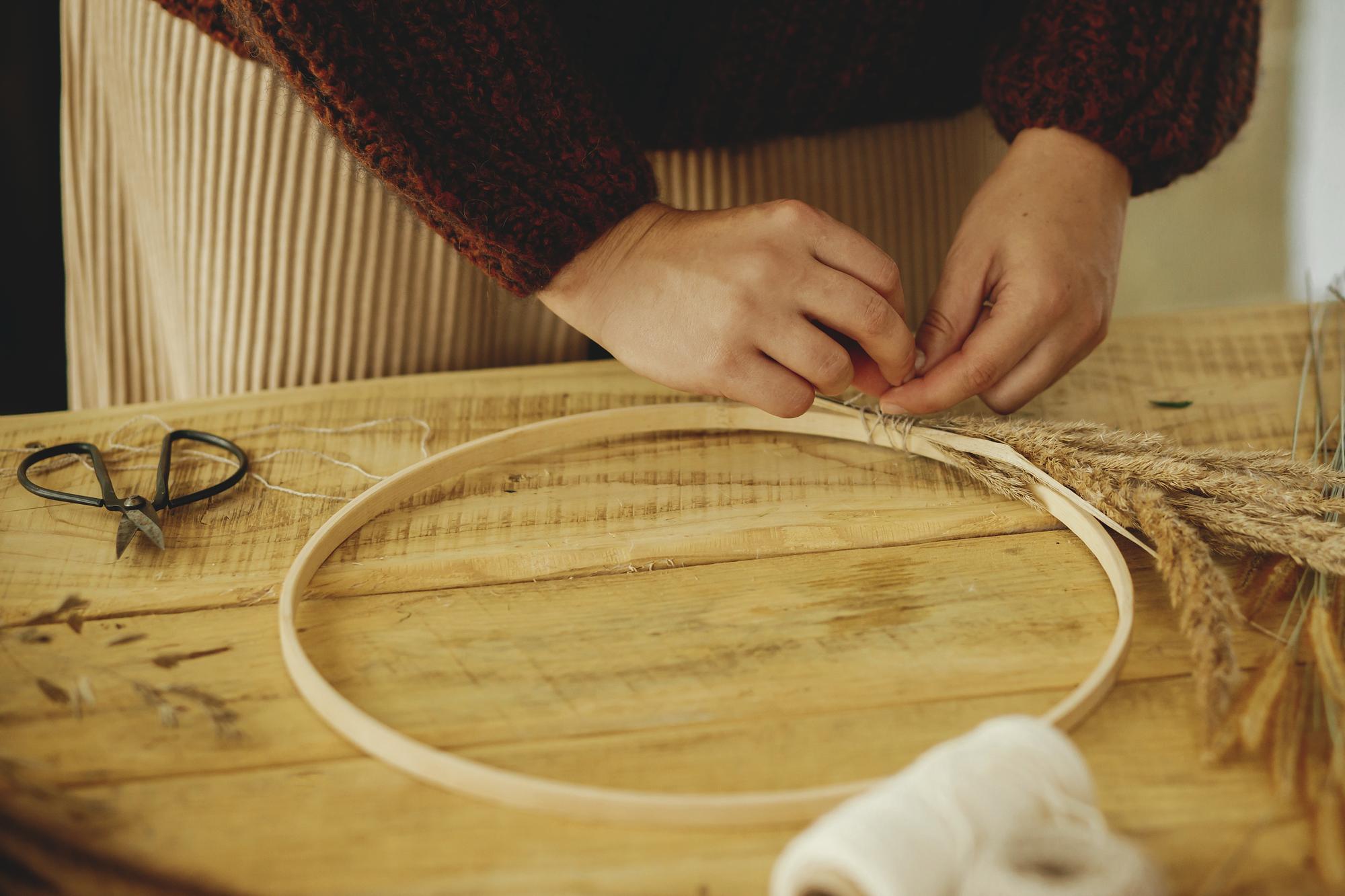 artisan at work with hoop and natural linen